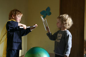zwei Jungen stehen sich wie Ritter mit Zollstöcken gegenüber